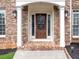 Beautiful brick home's front door framed by white columns and sidelights at 5009 Kingsley Manor Ct, Marietta, GA 30066