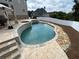 An in-ground pool with a hot tub surrounded by a stamped concrete patio with outdoor seating at 5009 Kingsley Manor Ct, Marietta, GA 30066