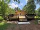 Backyard deck with steps leading down to a green lawn surrounded by trees at 2807 Mcclave Dr, Doraville, GA 30340