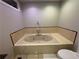 Bathroom featuring a large soaking tub with tile surround and chrome fixtures at 2807 Mcclave Dr, Doraville, GA 30340