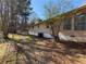 Home exterior featuring manicured lawn, mature trees, and windows that add natural light to the interior at 2807 Mcclave Dr, Doraville, GA 30340