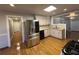 Updated kitchen offers stainless steel refrigerator, granite countertops, and wood floor at 2807 Mcclave Dr, Doraville, GA 30340