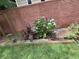 Landscaped garden bed against a brick wall with lush greenery and blooming flowers at 2807 Mcclave Dr, Doraville, GA 30340