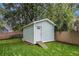 Backyard view of a storage shed with a white door and ramp set behind a wood privacy fence at 1292 Eubanks Ave, East Point, GA 30344