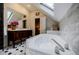 Bathroom with marble tile, tub, skylight, and antique vanity at 2007 Mount Vernon Pl, Dunwoody, GA 30338