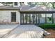 Back exterior of a white brick home featuring a lovely deck and sunroom at 2007 Mount Vernon Pl, Dunwoody, GA 30338
