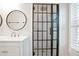 Modern bathroom features a glass-enclosed shower with black accents, plus a window for natural light at 4167 Oakwood Way, Duluth, GA 30096