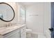 Cozy bathroom with round mirror and a pristine white vanity at 4167 Oakwood Way, Duluth, GA 30096
