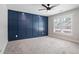 Bedroom features a ceiling fan, large window, blue accent wall, and gray carpet at 4167 Oakwood Way, Duluth, GA 30096