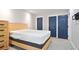 Bedroom with blue doors and wood furniture with a white mattress on a grey bed frame at 4167 Oakwood Way, Duluth, GA 30096