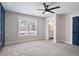 A bedroom boasts a blue accent wall, and carpeted floors. Natural light filters in through a window at 4167 Oakwood Way, Duluth, GA 30096
