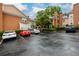 Wet paved parking lot with assigned spots surrounded by townhomes and mature landscaping at 7500 Roswell Rd # 18, Sandy Springs, GA 30350