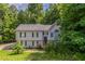 Traditional two-story home featuring neutral siding, black shutters, and mature trees in a serene, wooded setting at 1404 Lancaster Ct, Mcdonough, GA 30252