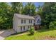 Two-story home with a two-car garage, long driveway, and lush, green lawn with beautiful, mature trees at 1404 Lancaster Ct, Mcdonough, GA 30252