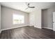 Bedroom with wood-look flooring, neutral paint, a large window, and a ceiling fan at 1947 Drew Nw Dr, Atlanta, GA 30318