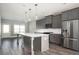 Open kitchen features gray cabinets, stainless steel appliances, a large island with pendant lighting, and wood-look flooring at 1947 Drew Nw Dr, Atlanta, GA 30318