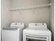 Bright laundry room with modern white washer and dryer, with wire rack shelving above at 1947 Drew Nw Dr, Atlanta, GA 30318