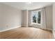Bedroom with wood floors, white trim, neutral walls, and a large window providing city views at 285 Centennial Olympic Park Nw Dr # 809, Atlanta, GA 30313