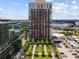 A high-rise building overlooks manicured grounds, a parking deck, and an outdoor pool on a sunny day at 285 Centennial Olympic Park Nw Dr # 809, Atlanta, GA 30313