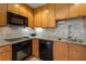 Modern kitchen with stainless steel appliances, wooden cabinets, and stylish backsplash at 285 Centennial Olympic Park Nw Dr # 809, Atlanta, GA 30313