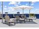 Relaxing rooftop deck with lounge chairs, tables, sun umbrella and blue sky at 285 Centennial Olympic Park Nw Dr # 809, Atlanta, GA 30313