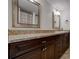 Bathroom with dual mirrors and granite countertop over dark wood cabinetry at 6851 Roswell Rd # G20, Sandy Springs, GA 30328