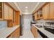 Galley kitchen featuring wooden cabinetry, stainless steel appliances, and subway tile backsplash at 6851 Roswell Rd # G20, Sandy Springs, GA 30328