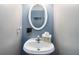 Powder room features a pedestal sink and decorative oval mirror at 739 E Mays E Rd, Stockbridge, GA 30281