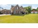 Two-story brick home features a well-manicured lawn, charming front porch, and a separate two-car garage at 739 E Mays E Rd, Stockbridge, GA 30281