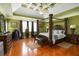 Large main bedroom with tray ceilings, a four-poster bed, and hardwood floors at 739 E Mays E Rd, Stockbridge, GA 30281