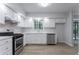 Bright kitchen equipped with stainless steel appliances, white cabinets, and hardwood floors at 740 Stoneside Ct, Stone Mountain, GA 30083