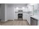 Modern kitchen featuring white cabinets, stainless steel appliances, and hardwood floors at 740 Stoneside Ct, Stone Mountain, GA 30083