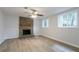 Spacious living room featuring a cozy brick fireplace, modern ceiling fan, and large windows for natural light at 740 Stoneside Ct, Stone Mountain, GA 30083