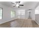Bright open-concept living area with hardwood floors, ceiling fan, and large windows at 740 Stoneside Ct, Stone Mountain, GA 30083