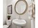 Neat half-bath with round mirror and decorative art print at 1399 Flathead River Ln, Marietta, GA 30064