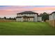 Back of a white, two-story home with a large backyard and a wooden fence at sunset at 3061 Bold Springs Rd, Dacula, GA 30019