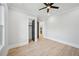 Spacious bedroom with light hardwood floors, a ceiling fan and two entry doors with a view to the kitchen at 3061 Bold Springs Rd, Dacula, GA 30019