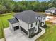 Aerial view of a modern home featuring a dark roof, white brick, and a spacious three-car garage at 3061 Bold Springs Rd, Dacula, GA 30019