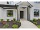 A close-up of the front door with a concrete walkway and landscaped garden at 3061 Bold Springs Rd, Dacula, GA 30019