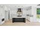 Bright kitchen features a dark island, white cabinets, marble backsplash, and stainless steel appliances at 3061 Bold Springs Rd, Dacula, GA 30019
