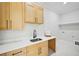 Well-lit laundry room with ample counter space, sleek wooden cabinets, and a modern sink at 3061 Bold Springs Rd, Dacula, GA 30019