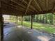 View of large backyard from under deck area showcases the brick pathway and wooded backdrop at 453 James Street Sw, Lilburn, GA 30047