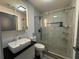 Stylish bathroom featuring marble walls, shower, and vessel sink at 453 James Street Sw, Lilburn, GA 30047