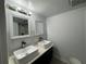 Bathroom featuring a glass-enclosed shower, and double vessel sinks at 453 James Street Sw, Lilburn, GA 30047