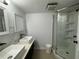 Bathroom featuring a glass-enclosed shower, and double vessel sinks at 453 James Street Sw, Lilburn, GA 30047