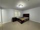 Tile floor bedroom with a wooden bedframe and nightstand, complemented by natural light and curtains at 453 James Street Sw, Lilburn, GA 30047