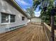 Spacious deck with wooden flooring attached to a white brick house, surrounded by lush trees at 453 James Street Sw, Lilburn, GA 30047