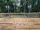 Wide, wooden deck featuring antique lamp posts and a view of a lush green backyard surrounded by trees at 453 James Street Sw, Lilburn, GA 30047