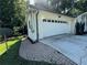 Exterior view of the garage with a white door, showing the brick-paved walkway and manicured landscaping at 453 James Street Sw, Lilburn, GA 30047