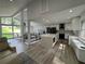 Bright, open concept living room with hardwood floors, large windows, and modern kitchen appliances at 453 James Street Sw, Lilburn, GA 30047